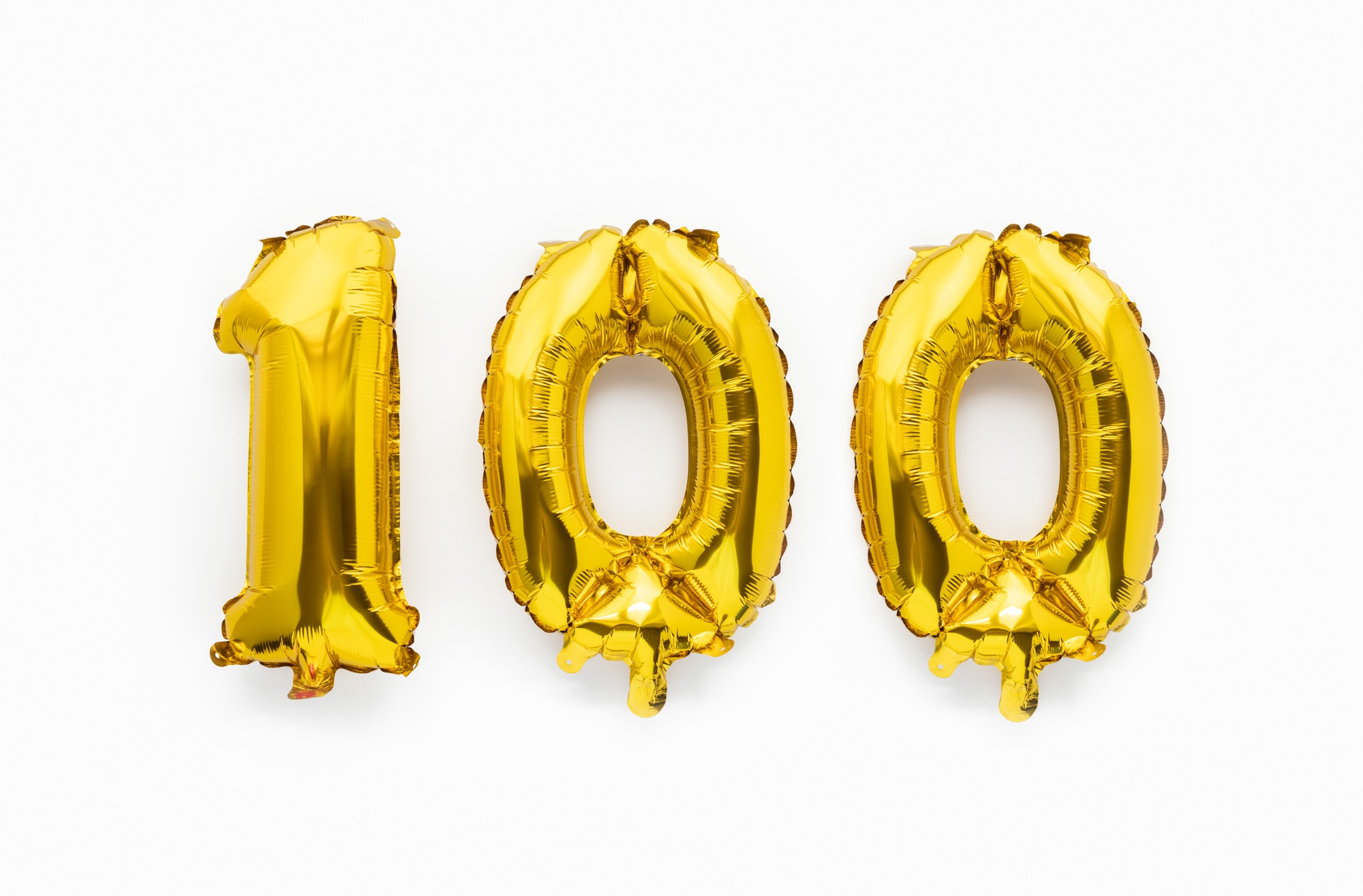 Number 100 one hundred golden foil balloon party decor on white background, birthday anniversary